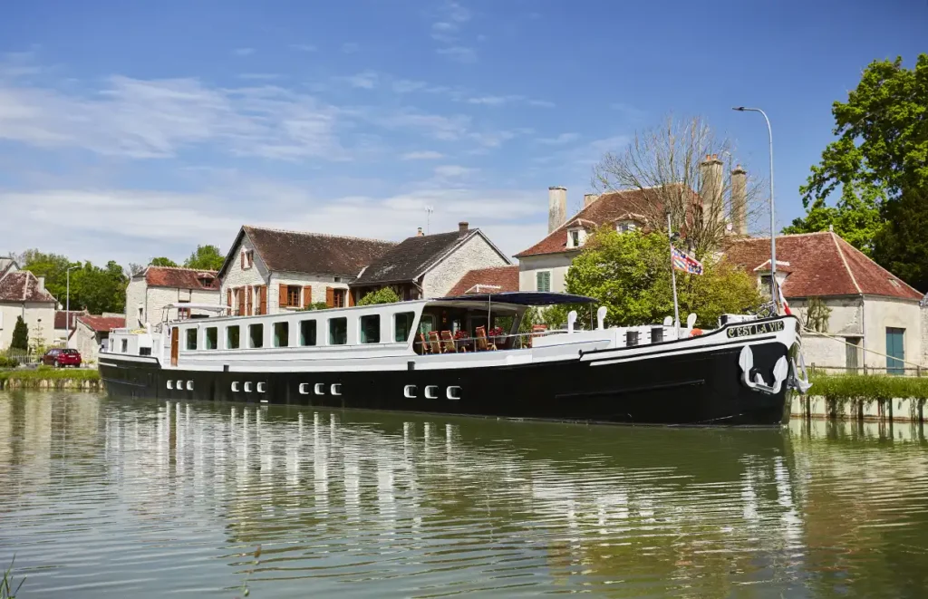 Barge C'est la Vie moored on a calm stretch of water