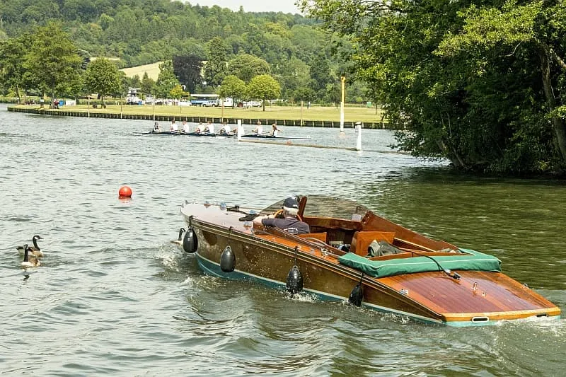 Wooden motorboat cruising on river